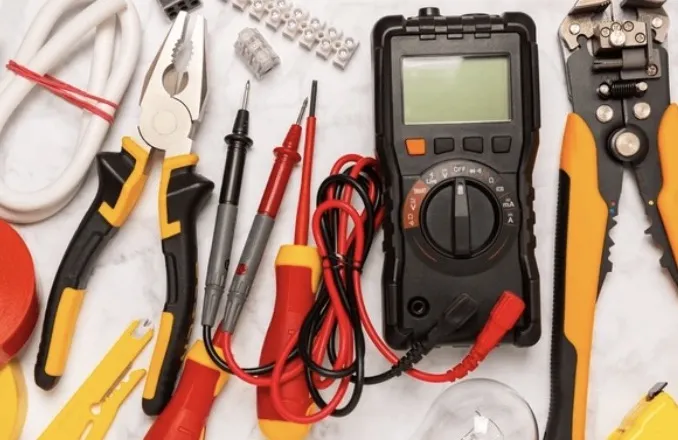 Gereedschap van de elektricien met multimeter, striptang en spanningzoeker