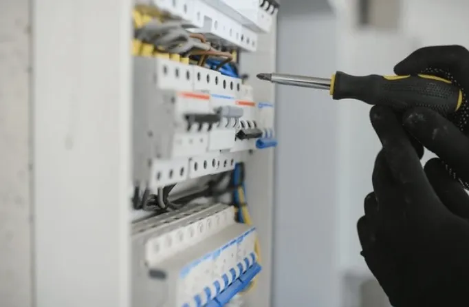 Elektricien draait een installatieautomaat vast in een groepenkast